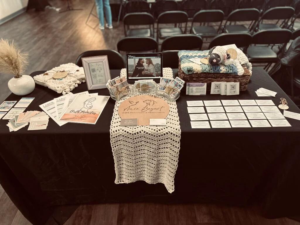 A doula table with brochures at a baby fair.