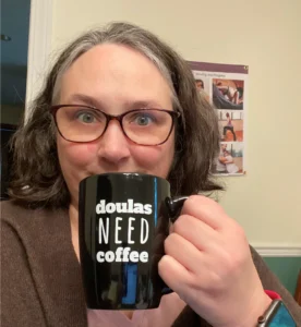 Robin Elise Weiss with a coffee mug that says Doulas Need Coffee